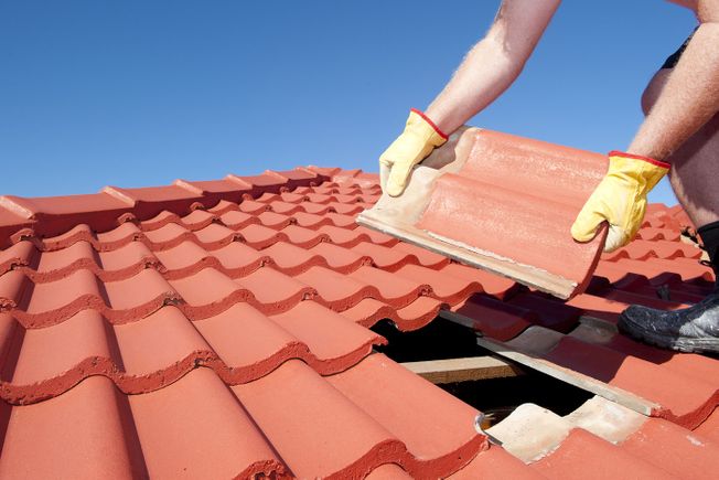 Roofer replacing a roof tile